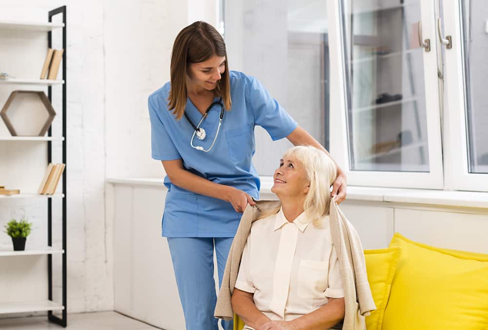 long shot nurse helping old woman with her coat