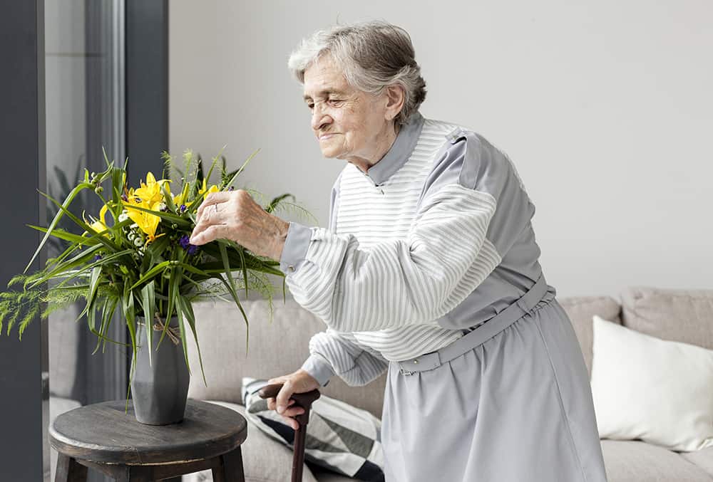 portrait elderly grandmother touching flowers