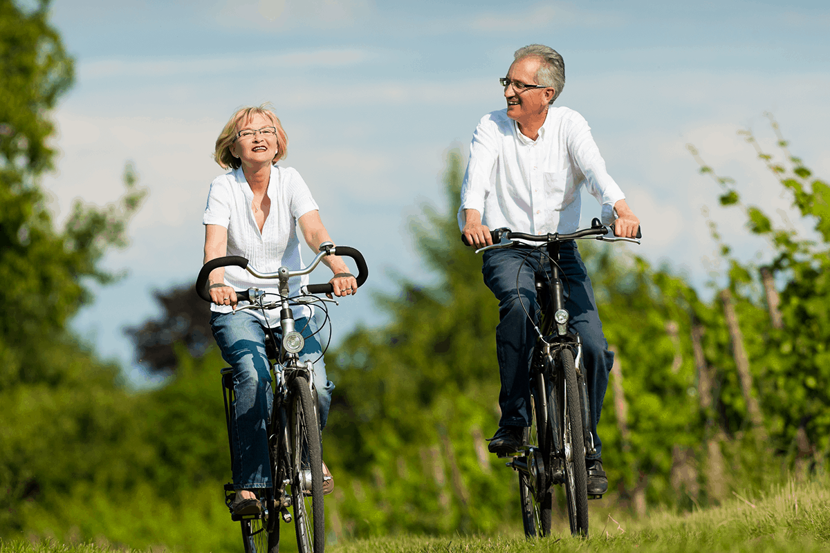 Older couple rides bikes outdoors