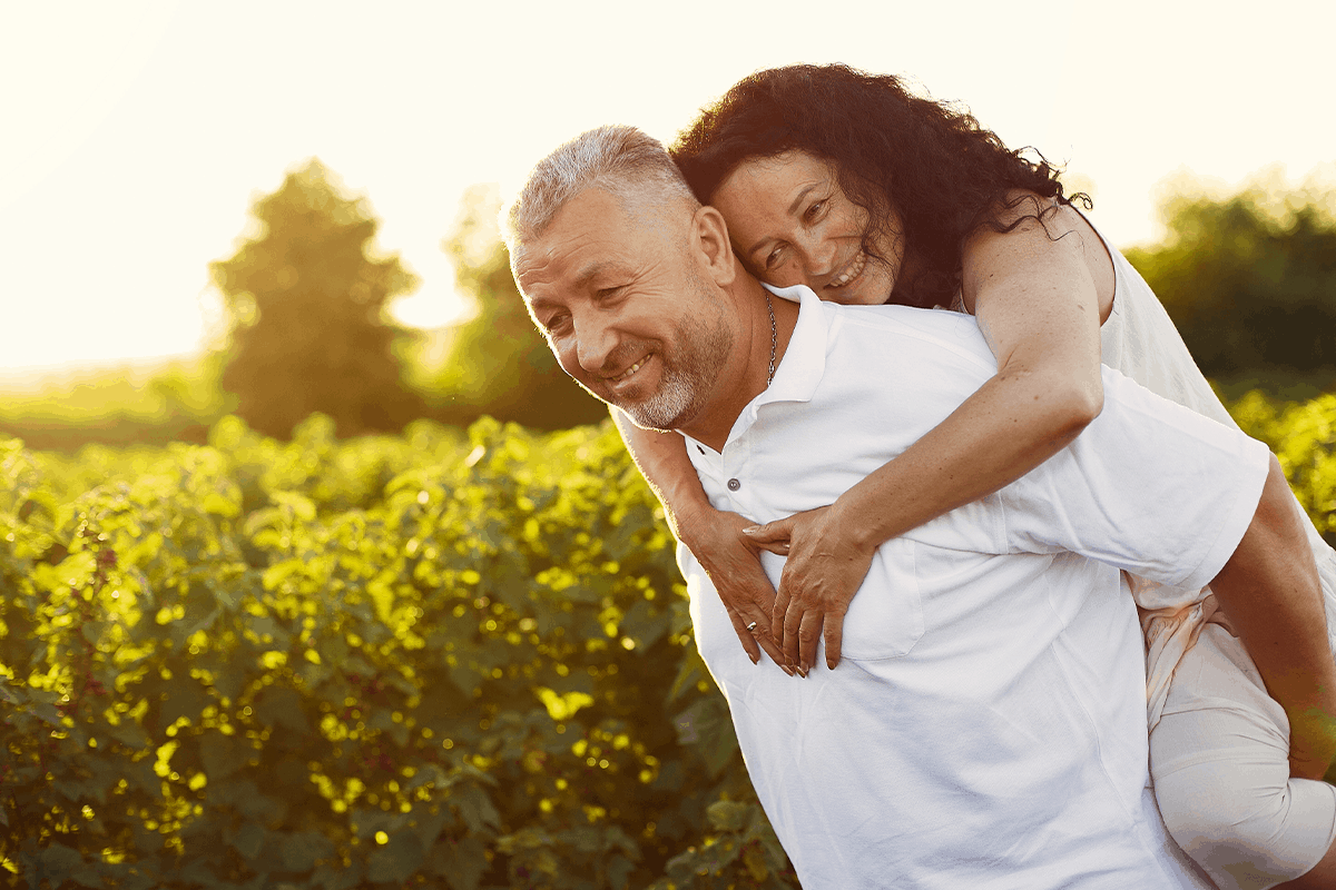 Couple play outdoors in fields at sunset