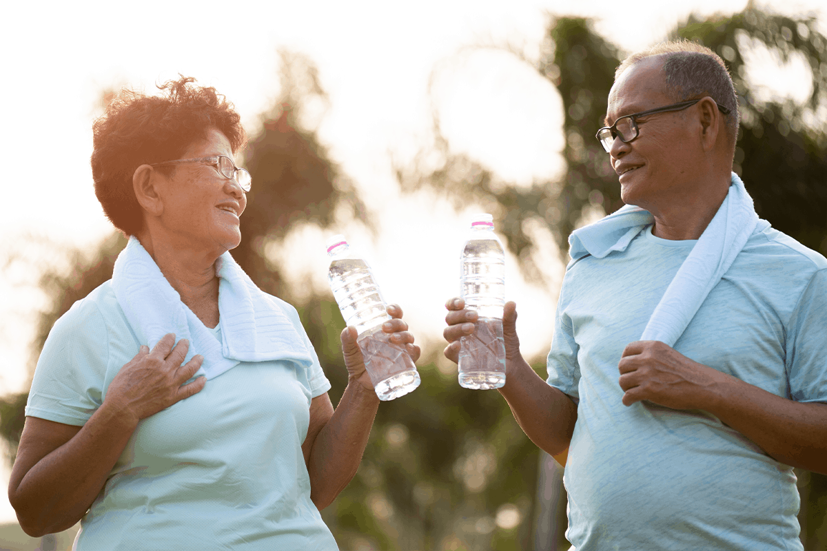 Older couple drink bottled water after exercise