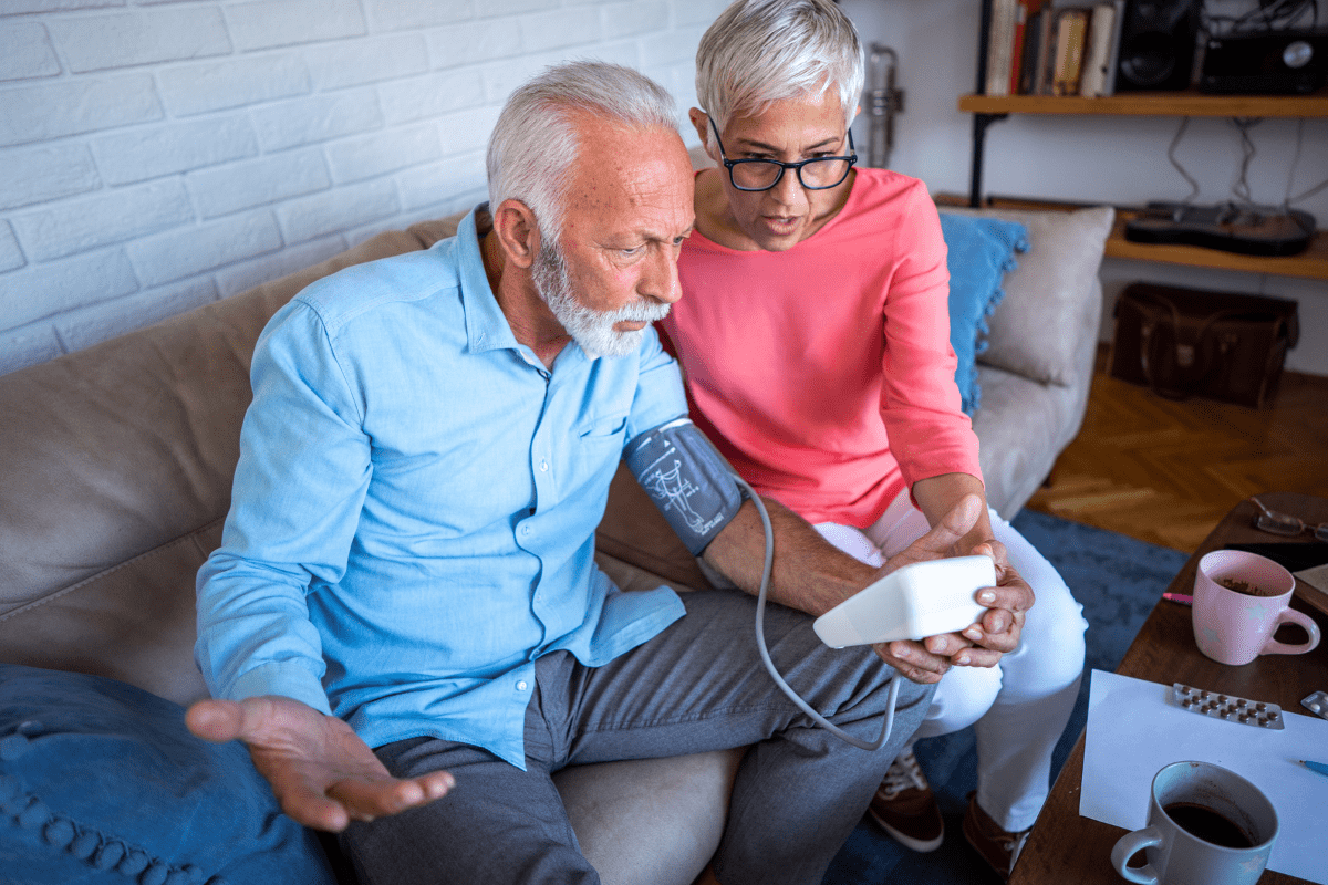 senior couple checking blood pressure with digital Sphygmomanometer