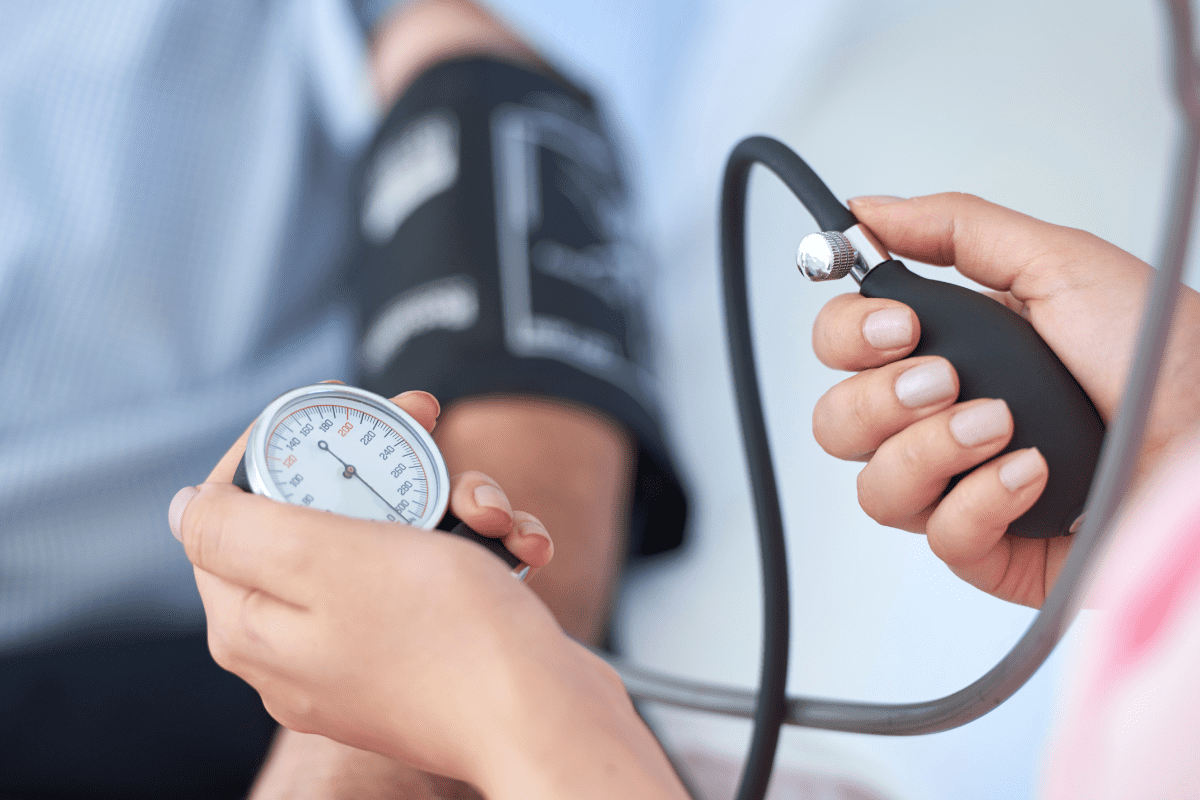Nurse taking mans blood pressure with Sphygmomanometer