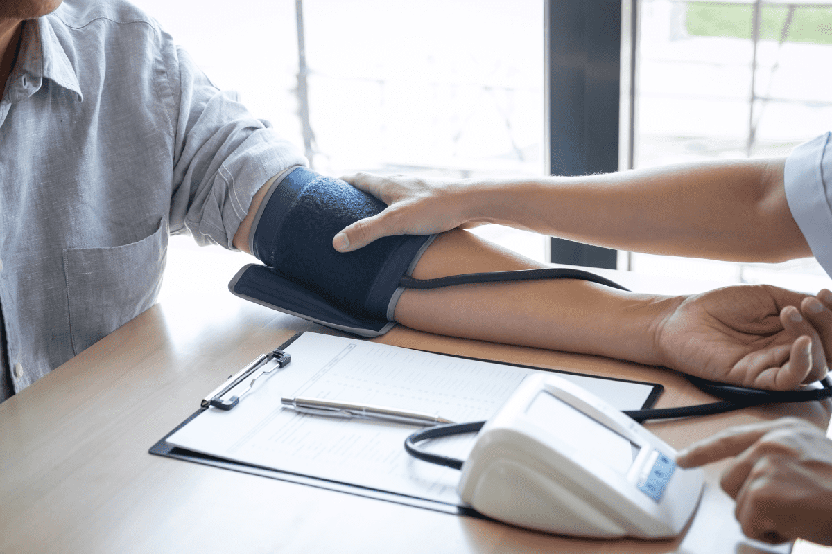 medical assistant takes mans blood pressure or heart rate with digital Sphygmomanometer