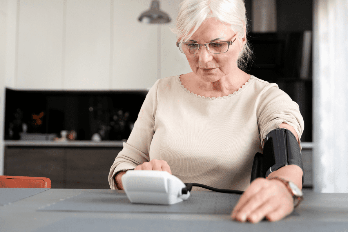 senior woman at home taking her own blood pressure with digital Sphygmomanometer