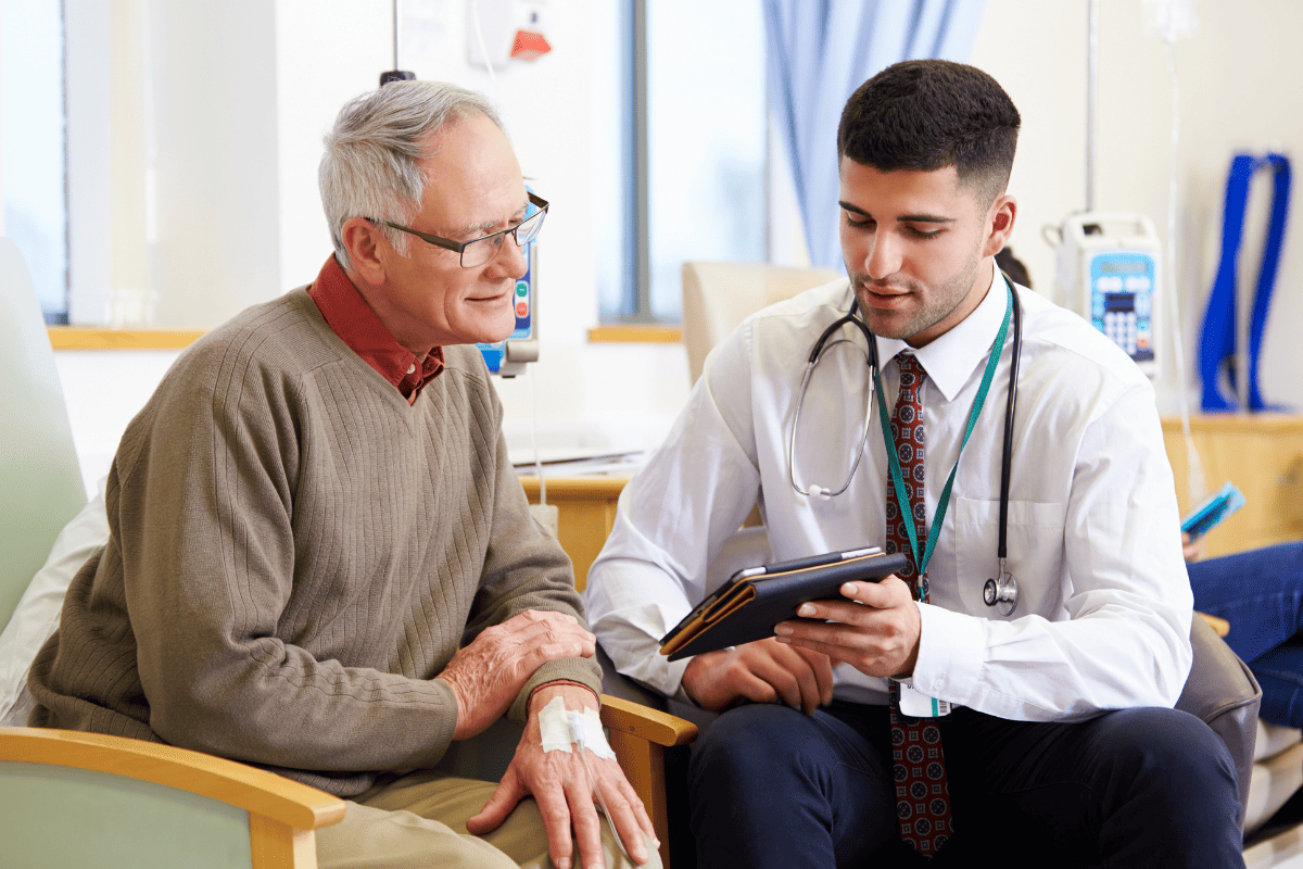 medical professional consultates senior man with digital tablet 
