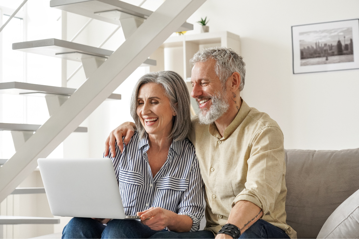 Senior couple at home using laptop
