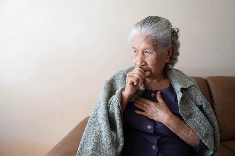 Senior woman indoors suffering from COPD